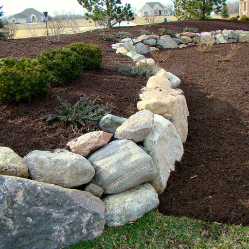 "Granite Boulders used in a landscaped garden bed"